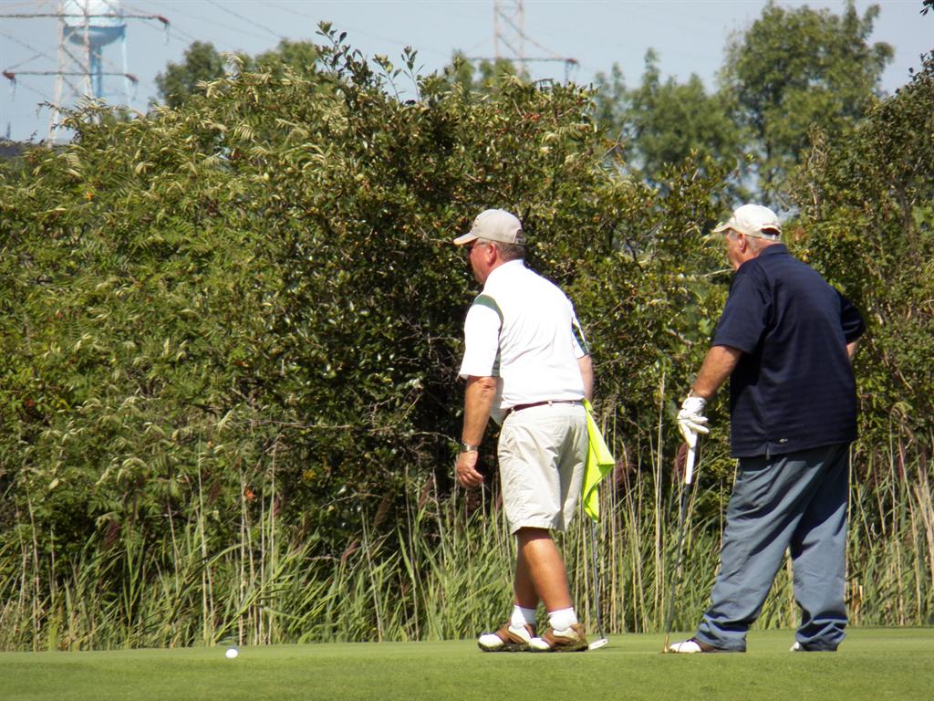 Fred Leonard lines up a putt on #14 while "Carpie"&nbsp; looks on.	